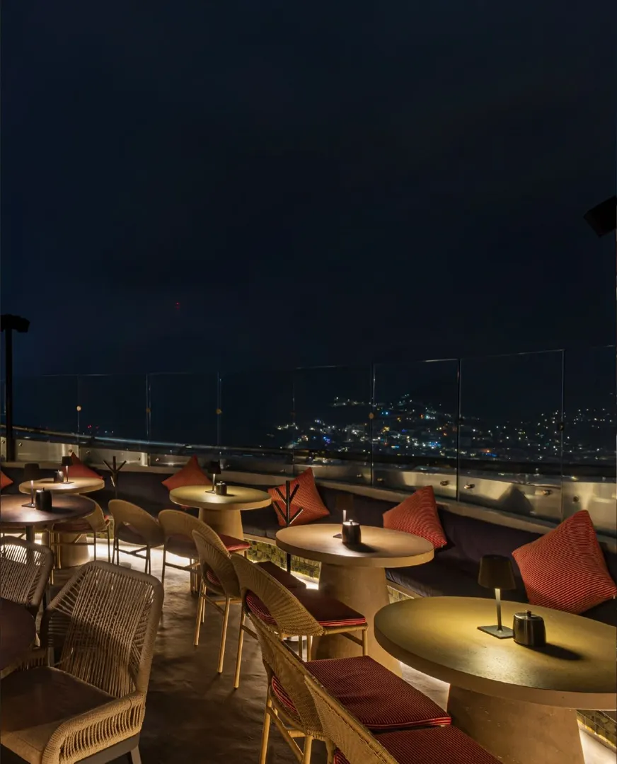 Cocteles elegantes servidos en una barra de rooftop con vistas panorámicas de la ciudad al atardecer en Sky Bar Monterrey.